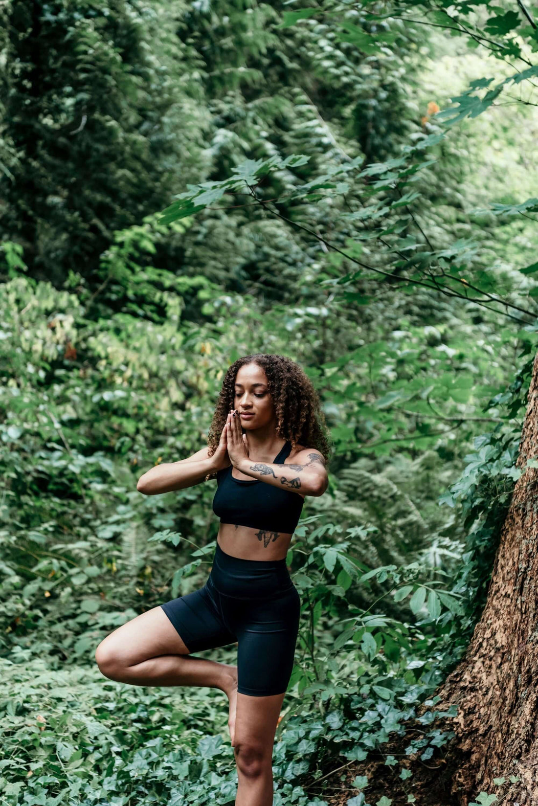 Frau Meditation im Wald als Symbol für innere Ruhe und Ausgewogenheit durch Ashwagandha